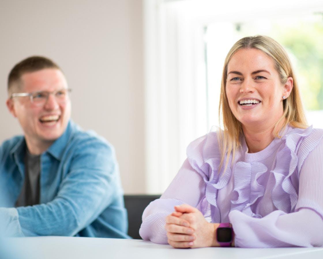 Een man en een vrouw zaten aan een bureau te lachen en te glimlachen